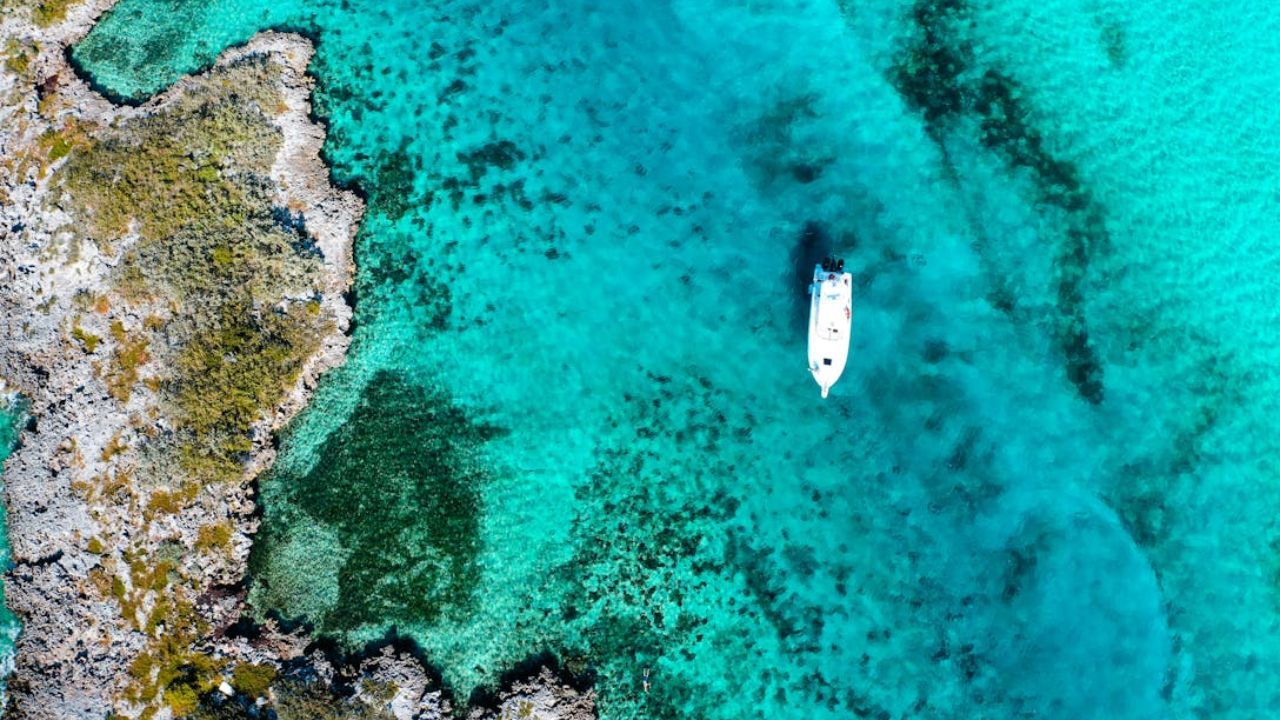 Bahamas aerial view with turquoise water, rocks, and boat. 
