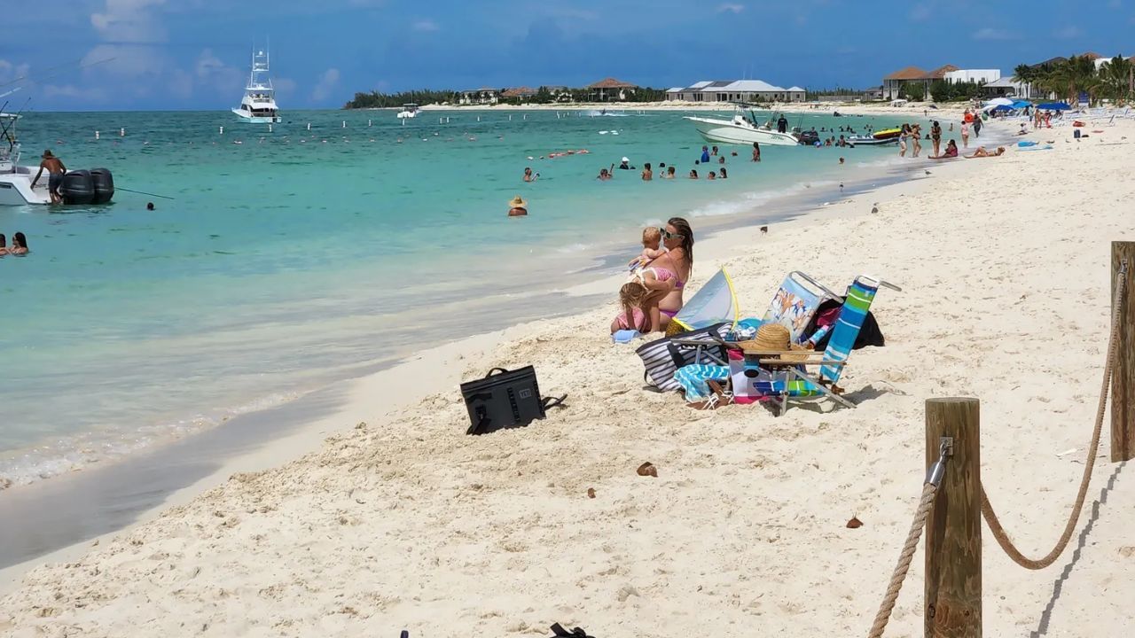 Bimini Beach with boats, swimmers, and turquoise tropical water.