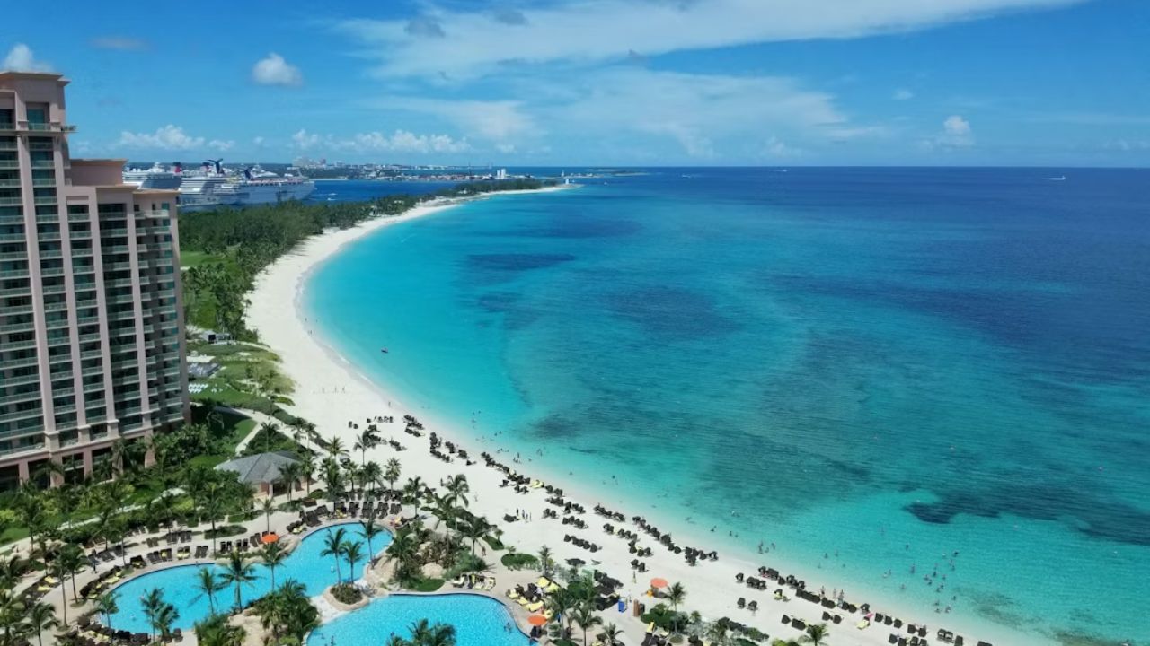 Bahamas resort with turquoise ocean, sandy beach, and cruise ships. 