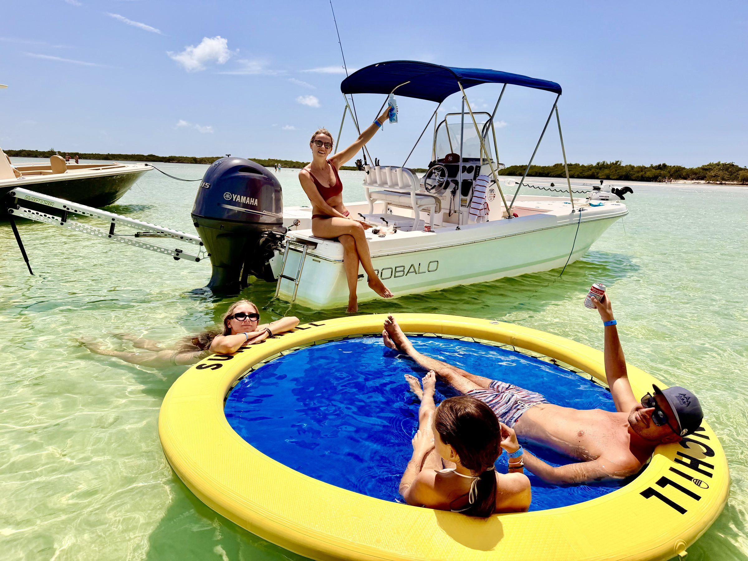 Guests relaxing on a floating pool mat next to the Robalo